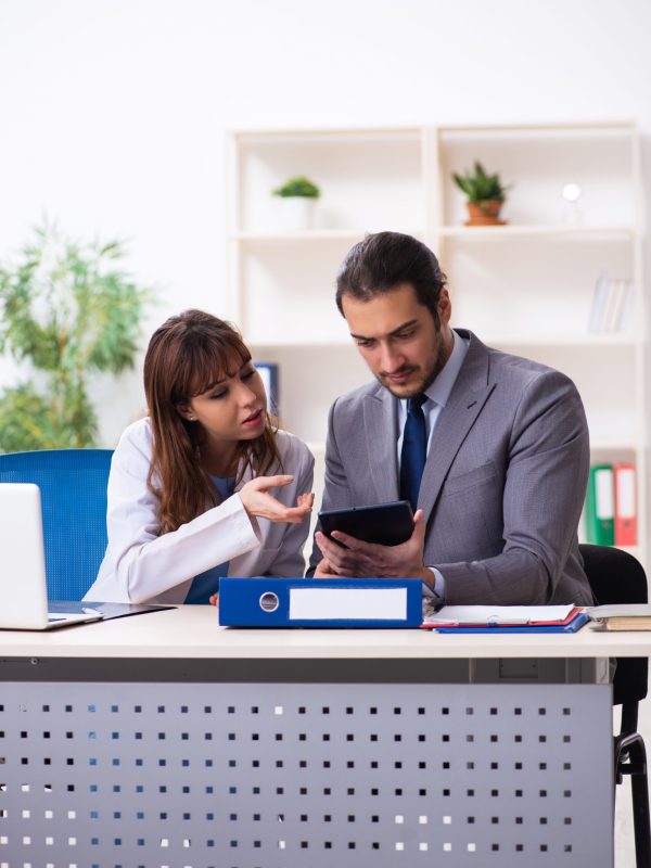 Young doctor and sick businessman in the office