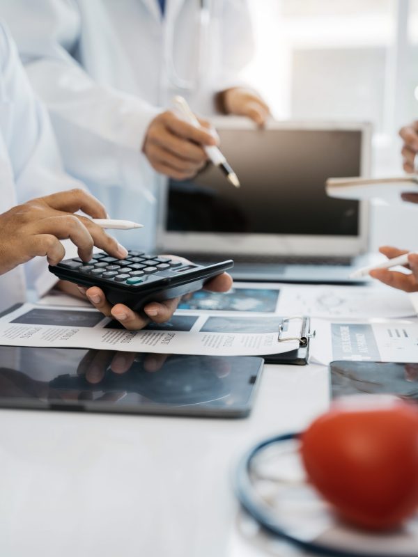 Doctors use a service fee calculator to save money on health insurance, drug cost concepts.